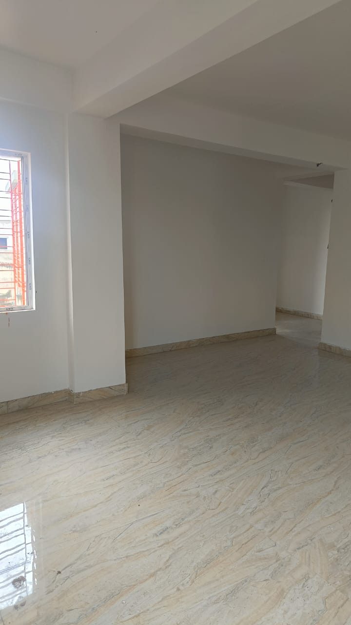 Spacious empty living room with a window at Krishna Lakeview, Kestopur