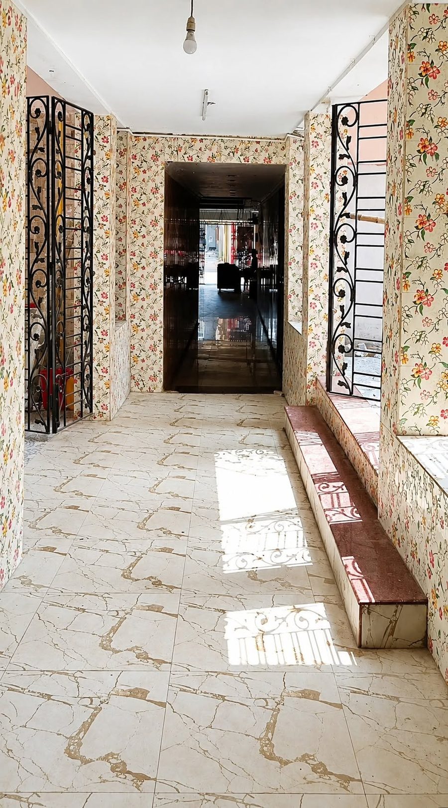 Entrance hall with floral wall tiles and wrought-iron grilles at Krishna Shivangan, Kestopur